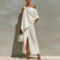 Woman wearing a white off-shoulder dress with a plain background