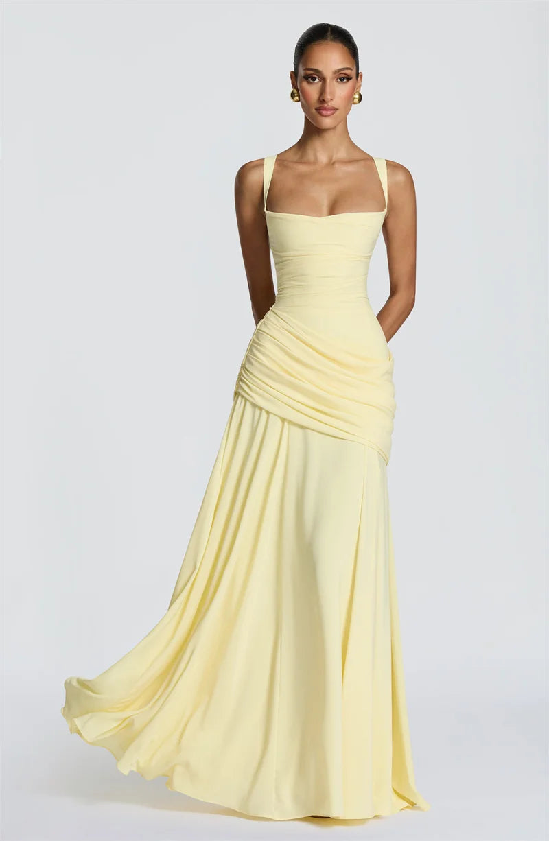 Woman wearing a light yellow evening gown on a plain background
