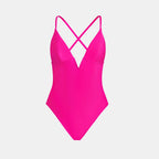 Pink swimsuit with criss-cross straps on a light gray background