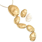 Gold necklace with textured beads on a white background