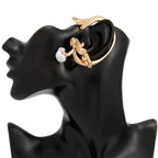 Gold and pearl earring on a black mannequin ear