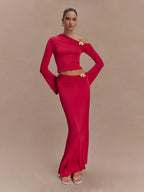 Woman wearing a red outfit with a gold belt on a beige background