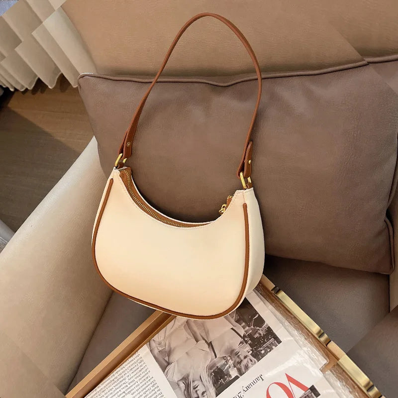Beige handbag with brown handle on a couch