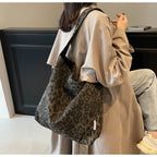 Person wearing a leopard print bag in an indoor setting