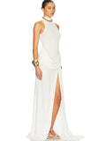Woman wearing a white halter neck gown with gold accessories on a white background