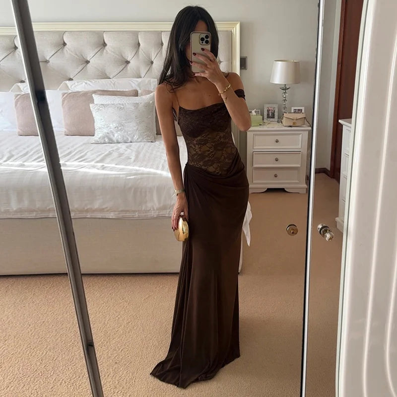 Woman taking a mirror selfie wearing a brown evening gown in a bedroom.