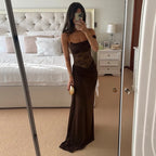 Woman taking a mirror selfie wearing a brown evening gown in a bedroom.