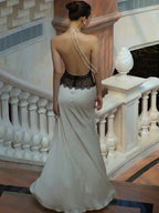 Woman in a white evening gown with a lace bodice standing on a staircase.