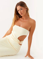 Woman wearing a strapless white dress with cut-out design on a white background