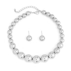 Silver beaded necklace and earrings set on a white background