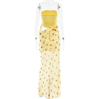 Yellow polka dot dress with clear plastic cover on a white background