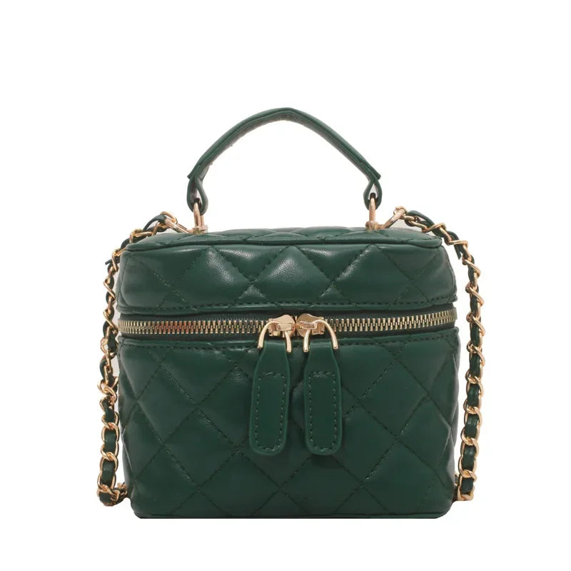 Green quilted handbag with gold chain strap on a white background