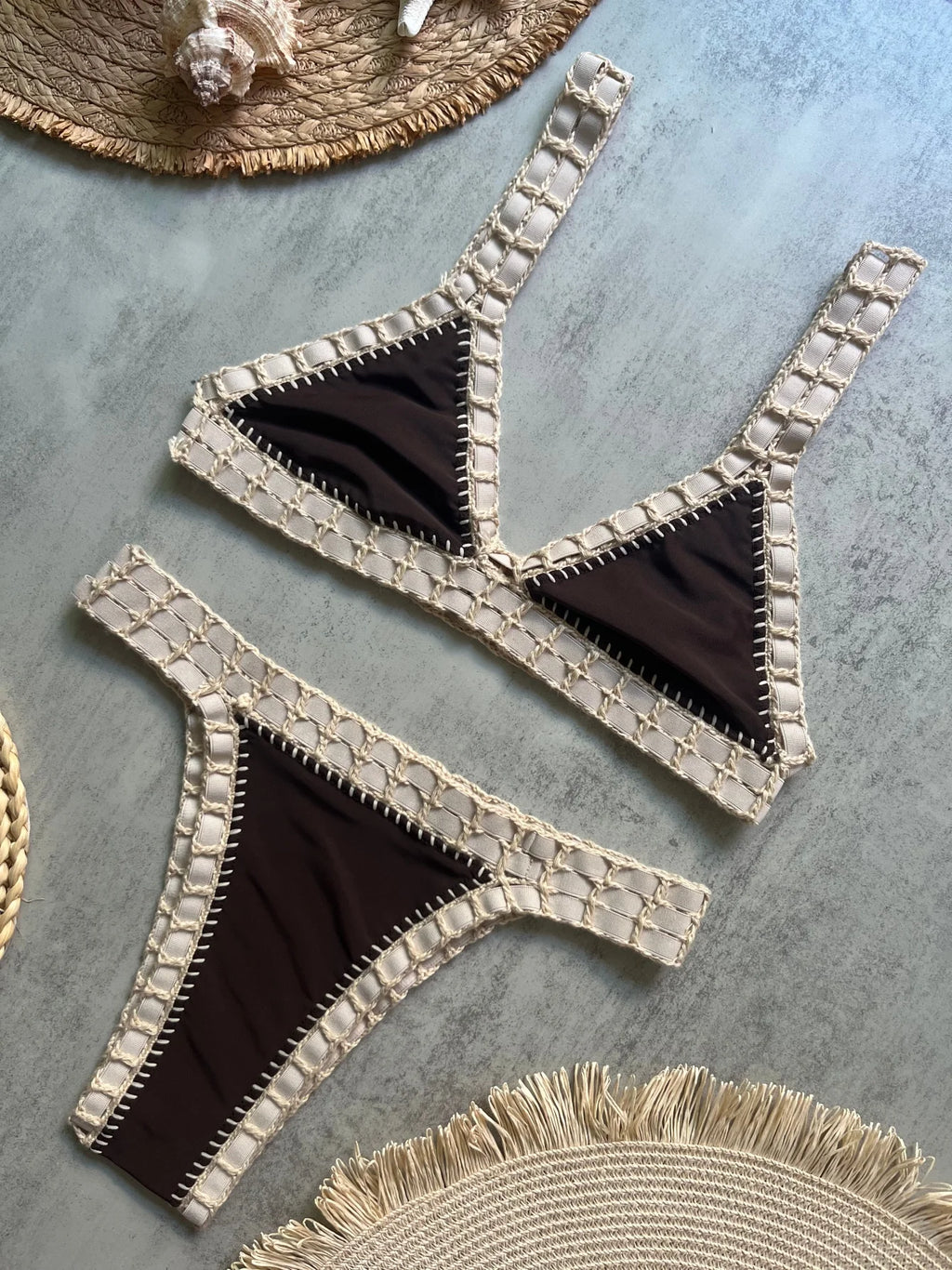 Black bikini with gold lace trim on a textured surface