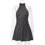 Black dress with white polka dots on a mannequin against a white background