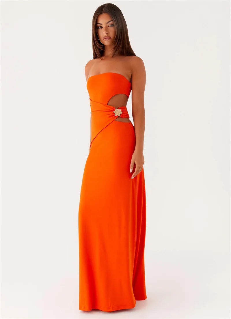 Woman wearing an orange strapless gown with cut-out design on a white background