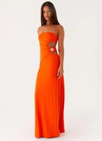Woman wearing an orange strapless gown with cut-out design on a white background