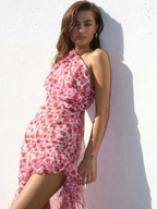 Woman wearing a pink floral dress against a white wall