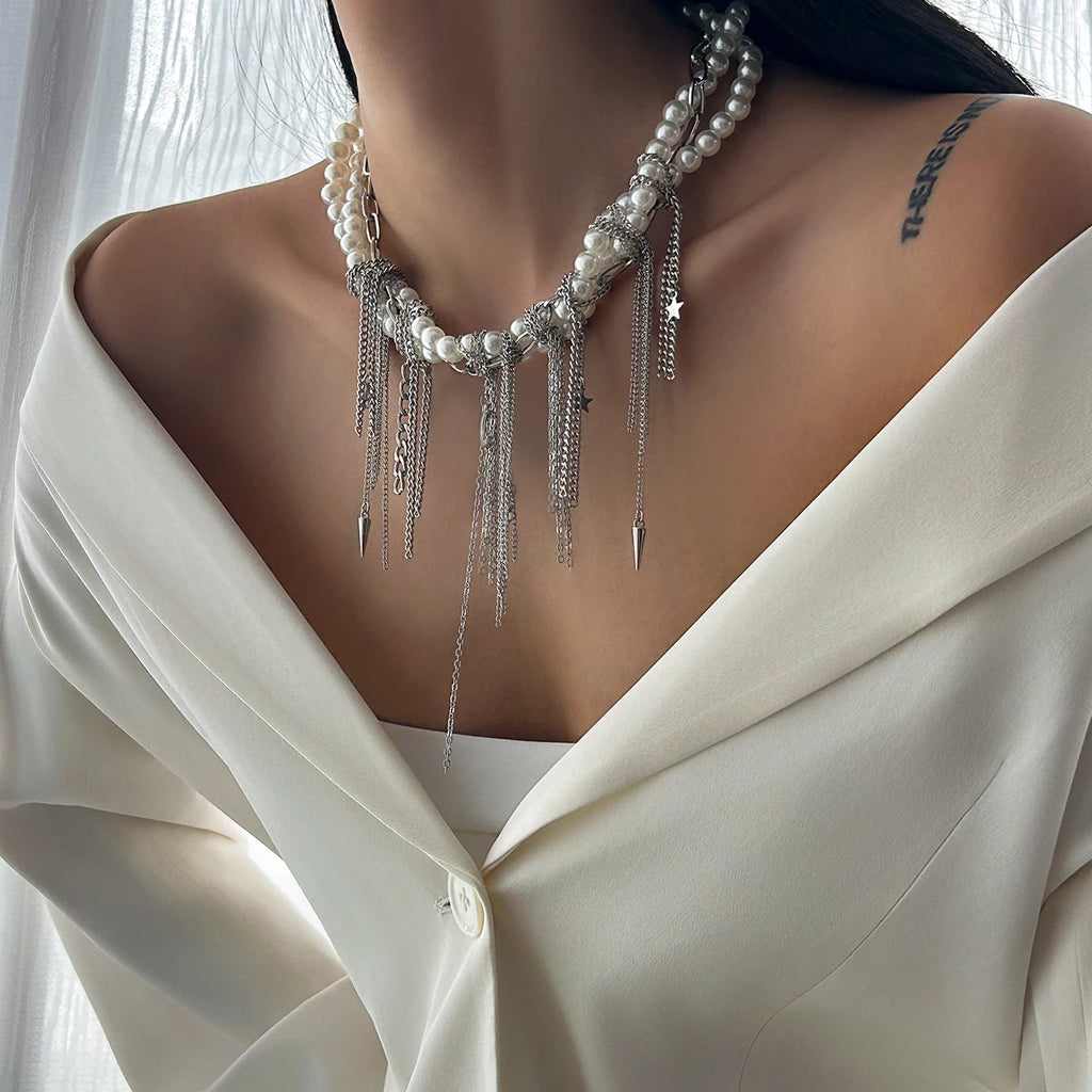 Pearl necklace with silver fringe on a person wearing a white blouse.