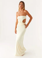 Woman wearing a strapless white evening gown with cut-out design on a white background