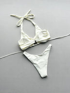 White bikini set with a bow detail on a gray background