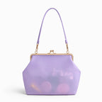 A lavender translucent clutch handbag with a gold-tone kiss-lock frame and a matching lavender shoulder strap, shown on a clean white background.