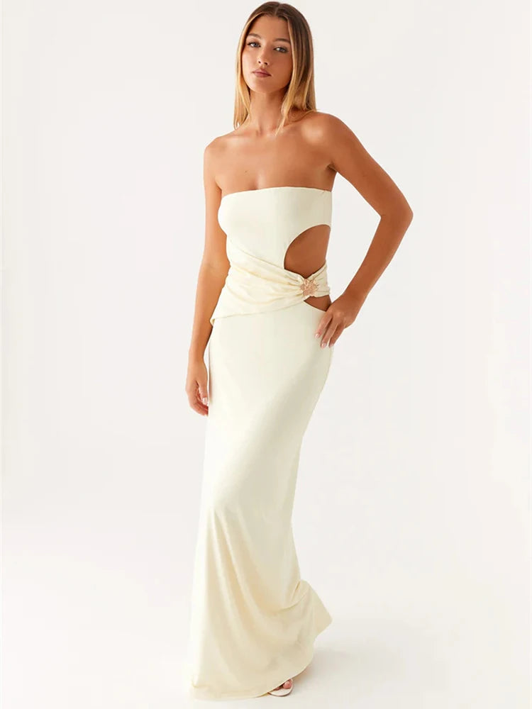 Woman wearing a strapless white evening gown with cut-out design on a white background