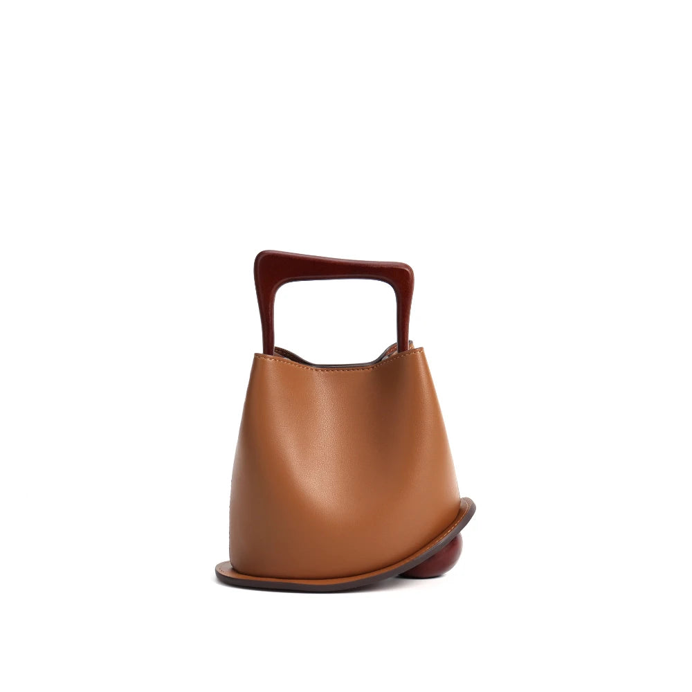 Brown leather handbag with a handle on a white background