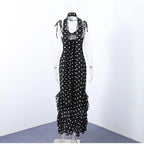 Black polka dot dress on a mannequin against a white background