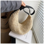 Woven handbag held by a person with a minimal background
