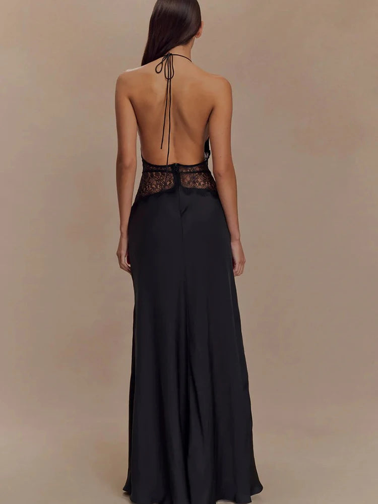 Black evening gown with open back on a plain background