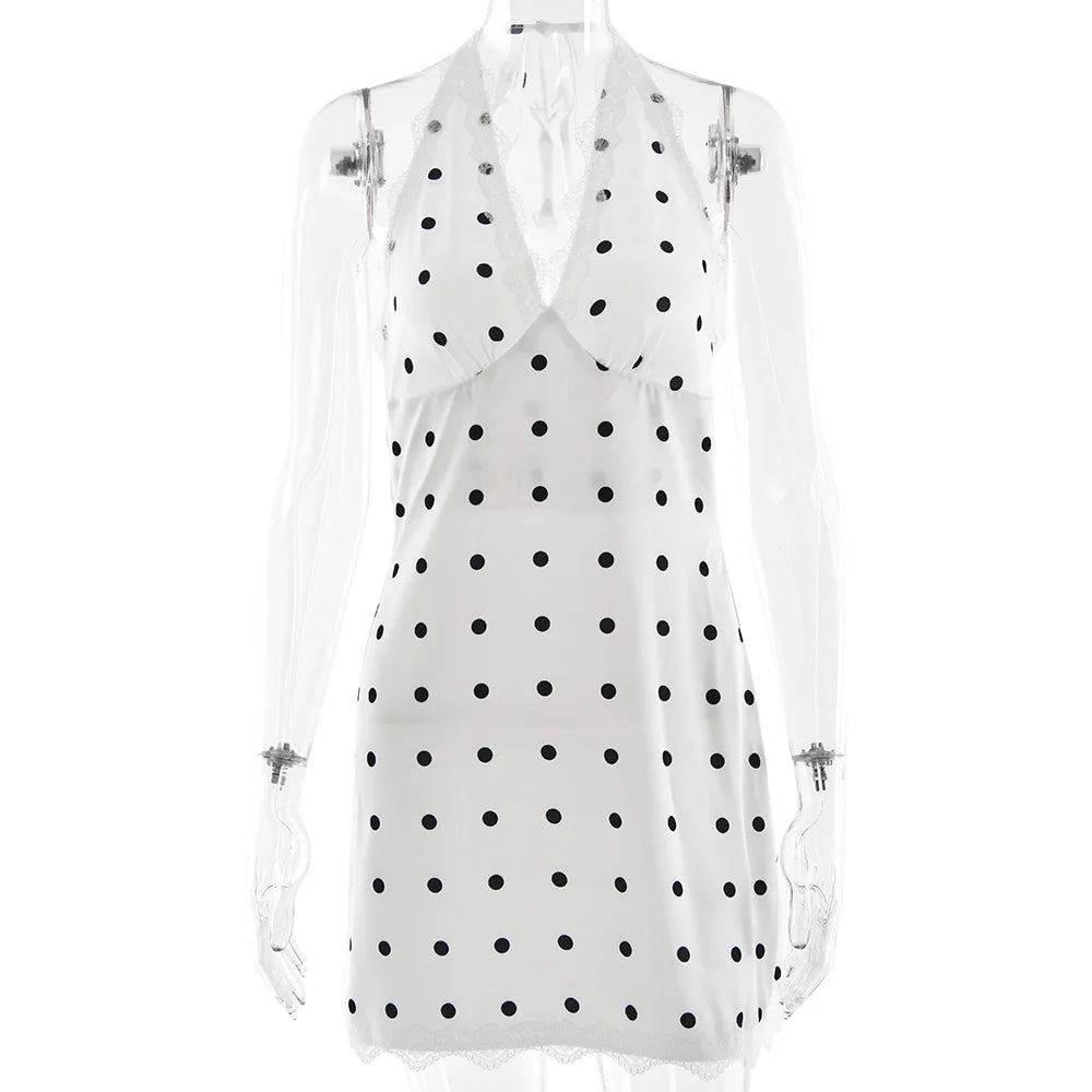 White sleeveless top with black polka dots on a white background
