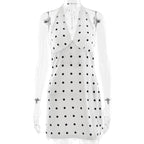 White sleeveless top with black polka dots on a white background