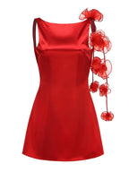 Red satin dress with floral embellishments on a white background