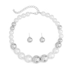 Pearl and silver necklace with matching earrings on a white background