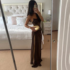 Person wearing a long brown dress in a bedroom setting