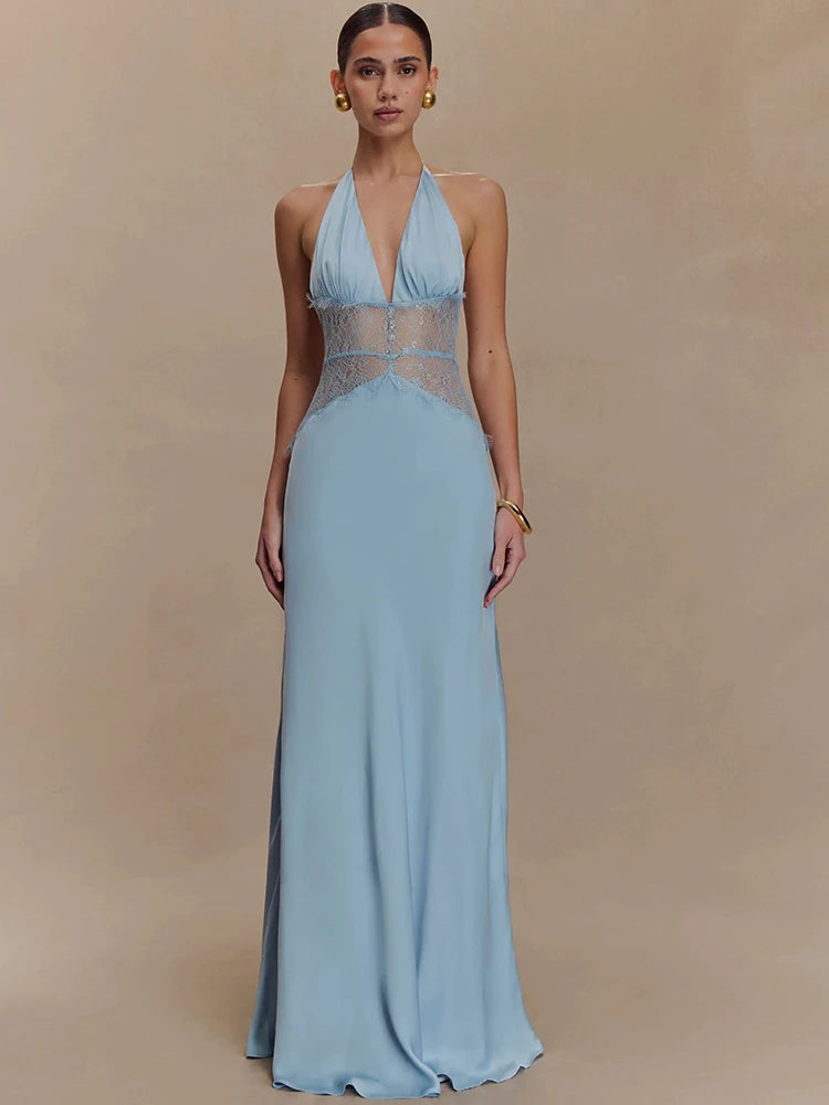 Woman wearing a light blue evening gown with sheer panels on a beige background