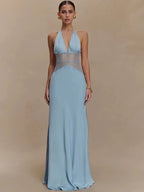 Woman wearing a light blue evening gown with sheer panels on a beige background