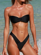 Woman wearing a black bikini set on a beach
