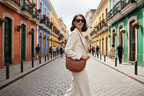 Elegant woman with Curved Saddle Crossbody Bag in vibrant city