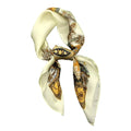 A silk scarf with a paisley pattern, primarily in beige, gold, and multicolor.