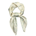 An ivory-colored paisley pattern scarf wrapped around a head, with a visible blue and green paisley design.