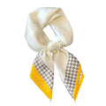 A white poly silk scarf with a houndstooth pattern, featuring a headband style with a yellow and beige color scheme.