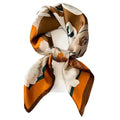 A scarf with a floral pattern, featuring a mix of mustard yellow, brown, and white colors, displayed on a mannequin.