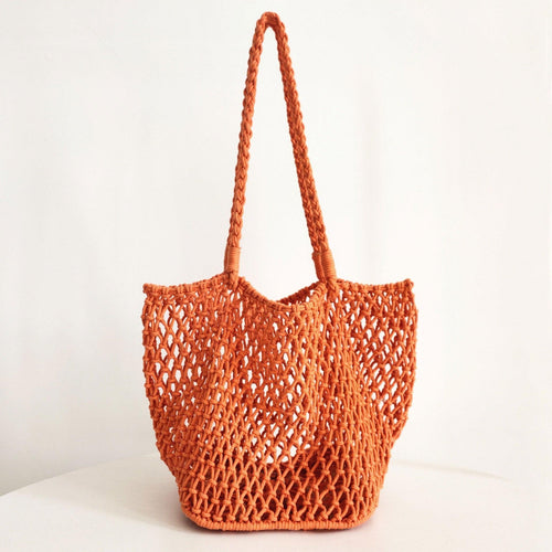 An orange hollow fishnet handbag with a shoulder strap on a white background.